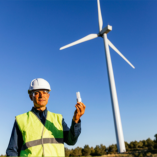 Hombre con bombilla y energía eólica